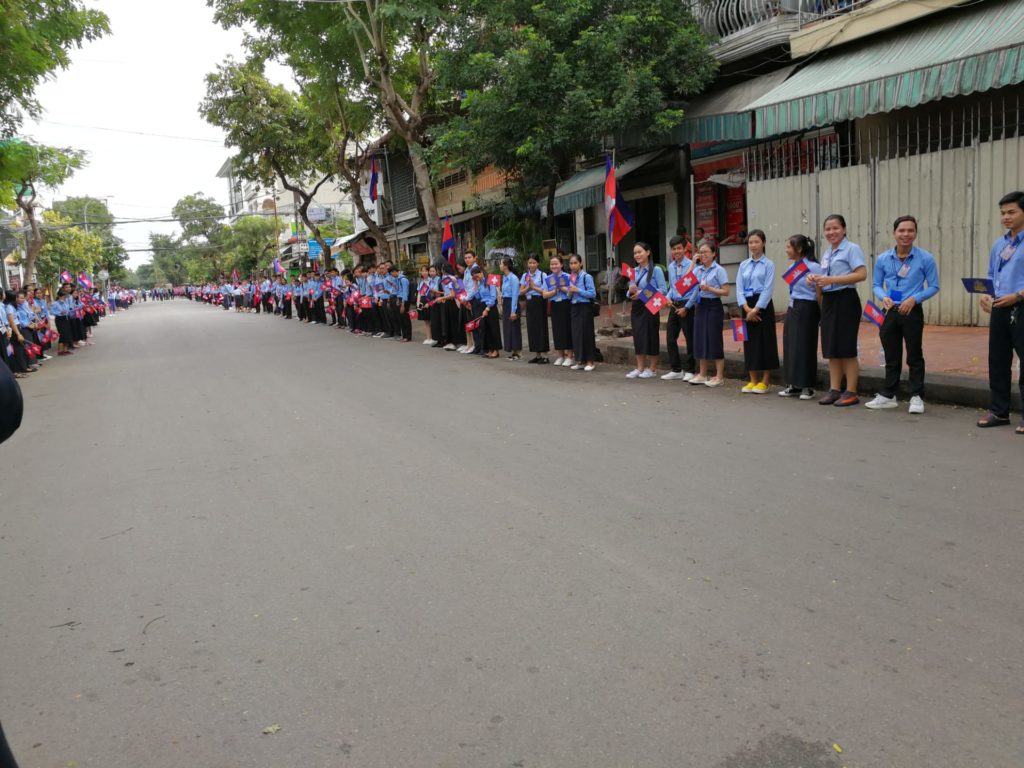La rue conduisant à l'hôpital. On a l'impression que tous les écoliers de Phnom Penh sont là pour nous faire une haie d'honneur (rarement vu autant de drapeaux suisses !).